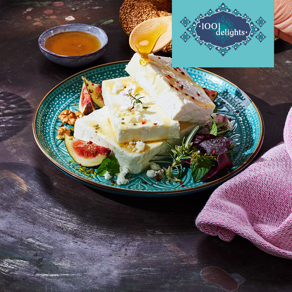 Feta met honing, vijgen en walnoten op een turquoise bord, met '1001 delights' logo.